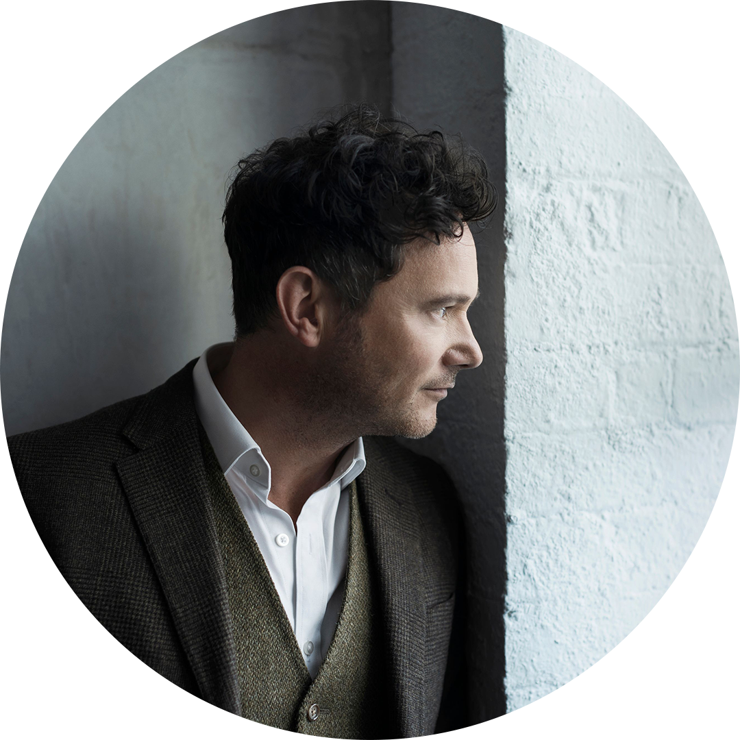 Kapellimestari Matthew Halls katsoo seinän vieressä kaukaisuuteen.